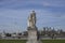 University of Greenwich - a view of the Canary Wharf and a statue against a blue sky.