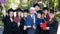 University professor and seven graduates rejoice at graduation.