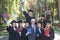 University professor and seven graduates rejoice at graduation.