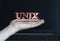 UNIX - word on a woman`s hand against the background of a laptop