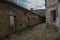 Unkempt Courtyard of an Old Prison Full of Weeds and Cells