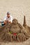 Unknown artist works on his sand Buddha sculpture in Los Cristianos Beach, Tenerife