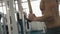 Unknown bodybuilder with naked torso is training his arms at the fitness station. 4k footage.