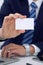 Unknown businessman or lawyer giving a business card while sitting at the table, close-up. He offering partnership an