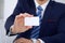 Unknown businessman or lawyer giving a business card while sitting at the table, close-up. He offering partnership an