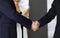 Unknown businesspeople are shaking their hands after signing a contract at meeting, close-up. Business communication