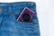 Unknown compact camera is lying in the side pocket of blue jeans