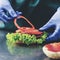 Unknown cook preparing veggie burger putting sliced tomatoes on