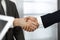 Unknown diverse business people are shaking hands finishing contract signing, close-up. Business and handshake concept