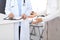 Unknown doctor and female patient discussing something while standing near reception desk in emergency hospit