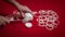 Unknown female chef slicing onion on red table. Woman hands cuttiong onion