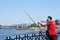 An unknown fisherman catches fish from the bridge.