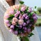 Unknown girl holding beautiful gentle bouquet with pink and purp