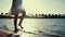 Unknown girl walking in warm seawater in sunrise. Woman legs splashing water