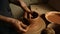 Unknown girl working with wet clay in pottery. Woman sculpting clay pot