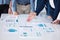 Unknown group of diverse businesspeople using paperwork during a boardroom meeting in an office. Closeup of colleagues