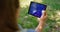 Unknown hands holding tablet on nature. Unrecognizable man have gadget on picnic