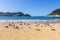 Unknown people relax on the beach called La Concha. Beautiful bay of Biscay in San Sebastian. Wide aerial beach on sunny day.