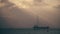 Unknown sailboat and cargo ship at sea in the evening