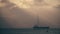 Unknown sailboat and cargo ship at sea in the evening