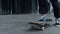 Unknown skater riding on board outdoor. Unrecognizable man feet skating outside.