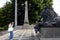 Unknown tourists are photographed at a bronze sculpture of a lion - a fragment of the monument to Alexander II in Moscow