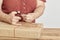 Unknown woman cutting a cord, tying a Christmas gift with a decorative string