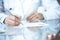 Unknown woman doctor at work at hospital. Pills at medical clipboard. Young female physician write prescription or