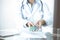 Unknown woman doctor at work at hospital. Pills at medical clipboard. Young female physician write prescription or