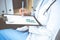 Unknown woman doctor at work at hospital. Pills at medical clipboard. Young female physician write prescription or