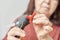 Unknown woman doing Christmas crafts, using a hot silicone gun to glue a red bow