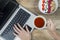 Unknown woman with laptop at breakfast time