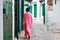 Unknown woman in national clothes on the old street in Tetouan Medina quarter in Northern Morocco. A medina is typically walled,