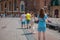 Unknown young women as tourists are taking photographs and selfies in front of saint mary basilica in Krakow old town on a clear