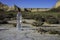 Unlabeled plastic water bottle on arid soil into desertic landscape