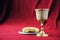 Unleavened bread, chalice of wine, silver kiddush wine cup on red background. Communion still life. Christian communion concept