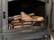 Unlighted firewood in a stove of a modern cast iron fire place, prepared to be burn up for heating a country house in