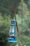 Unlit Kerosene lantern hanging off of a curved iron rod.