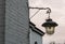 Unlit old and dirty vintage street lantern hanging on a brick wall