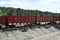 Unloading bulk cargo from railway wagons on of high railway platform.