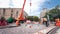 Unloading concrete plates from truck by crane at road construction site timelapse.