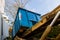 Unloading empty dumpster, recycle waste and garbage bins near new construction site of appartment houses building