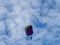 An unmanned aerial vehicle observes the parachutist soaring on the background of the cloudy sky