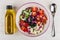 Unmixed ingredients of greek salad in bowl, vegetable oil, spoon