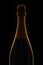 Unopened bottle of Champagne against a black background, silhouette with side highlights