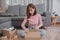 Unpack package and open parcel when online shopping and good delivery. Asian woman lifestyle in living room at home.