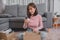 Unpack package and open parcel when online shopping and good delivery. Asian woman lifestyle in living room at home.