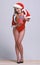 Unpacking gift sexy surprise. Woman attractive santa celebrate new year with gift. Girl swimsuit santa hat high heels