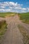 Unpaved dirt farm road through the Palouse region of Eastern Washington State on a sunny summer day