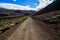 Unpaved dirt mountain road under blue cloudy sky in the Canary Islands, Spain